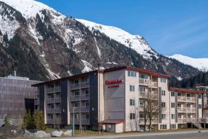 a hotel in front of a mountain with snow at Ramada by Wyndham Juneau in Juneau