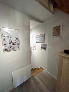 une chambre avec des murs blancs et des photos sur le mur dans l'établissement Neptune - SILS, à Douvres-la-Délivrande
