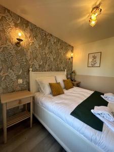 - une chambre dotée d'un lit avec une couverture verte et blanche dans l'établissement Neptune - SILS, à Douvres-la-Délivrande