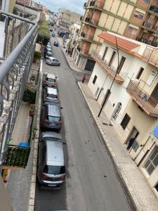 una fila de autos estacionados en una calle con edificios en casa vacanza con terrazza en Laterza