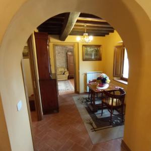 einen Torbogen in einem Zimmer mit einem Tisch und Stühlen in der Unterkunft Il casale del Domo in Monsummano