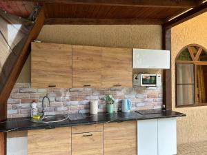 a kitchen with a sink and a brick wall at Gostevoy Dom in Pizunda