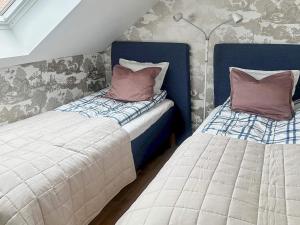 two beds sitting next to each other in a room at Holiday home HELSINGBORG in Helsingborg