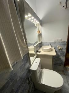 y baño con aseo, lavabo y espejo. en Apartamento 31 Ses Torretes en Cala Morell