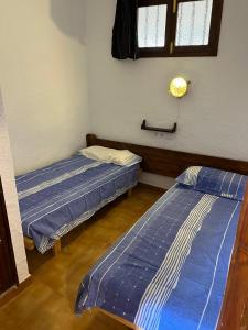 2 łóżka w małym pokoju z zapaleniem kręgosłupa, co oznacza zapalenie kręgosłupa, w obiekcie Apartamento 31 Ses Torretes w mieście Cala Morell