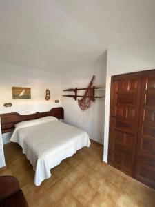 una camera con un letto bianco e una porta in legno di Apartamento 31 Ses Torretes a Cala Morell