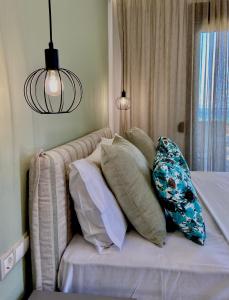 uma pilha de almofadas numa cama num quarto em THEA Luxury Apartments em Vourvourou