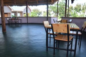 Kili View Lodge في موشي: مطعم فيه طاولات وكراسي في الغرفة
