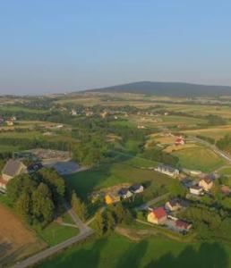an overhead view of a field with a river and houses at Agroturystyka Parcele 