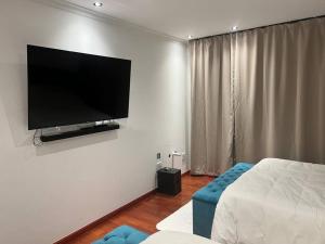 a bedroom with a flat screen tv on the wall at Amazing! 7 bedroom villa with rooftop pool & views in Cape Town