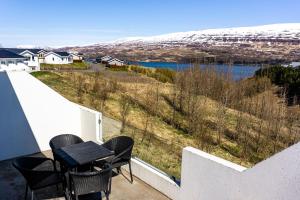 uma varanda com uma mesa e cadeiras e um lago em Saeluhus Apartments & Houses em Akureyri