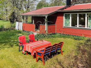 a red house with a table and chairs in front of it at Holiday home AXVALL in Axvall