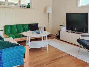 a living room with a couch and a table and a tv at Holiday home AXVALL in Axvall