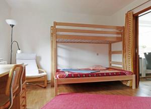 a bedroom with a bunk bed and a chair at Das Meininger Ferienhaus in Meiningen