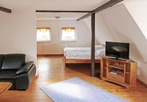 a living room with a bed and a television at Das Meininger Ferienhaus in Meiningen