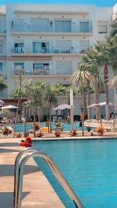 una piscina frente a un gran edificio en superbe appartement en résidence balnéaire en Bouznika