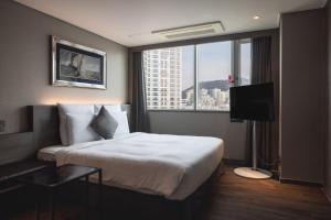 a hotel room with a bed and a large window at Kent Hotel Gwangalli by Kensington in Busan