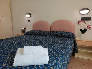 a bedroom with a blue bed with two towels on it at Residence Queen Mary in Cattolica