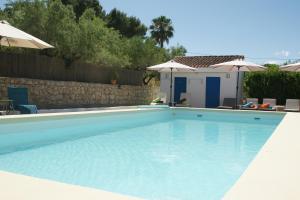 a large blue swimming pool with umbrellas at B&B Casa Vitalidad in Ontinyent