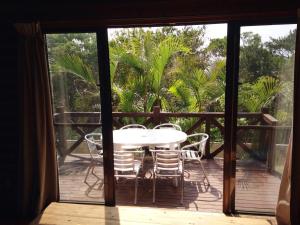 a patio with a table and chairs on a deck at Tokashiki Guest House in Tokashiki