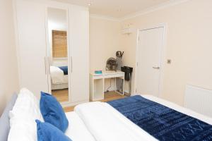 a white bedroom with a bed and a desk at Evergreen Apartments-Flat 5, London in London