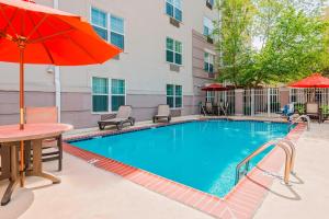 a swimming pool with a table and an umbrella at TownePlace Suites by Marriott Springfield in Springfield