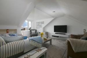 a living room with two couches and a flat screen tv at Willows in St Ives