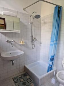 W łazience znajduje się wanna, umywalka i prysznic. w obiekcie Róza Hotel és Apartmanház w mieście Ostrzyhom