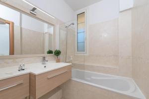 a bathroom with a tub and a sink and a shower at Hôtel Beau Site - Cap d'Antibes in Antibes