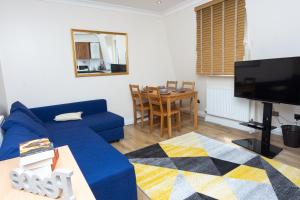 un soggiorno con divano blu e tavolo di Evergreen Apartments-Flat 5, London a Londra