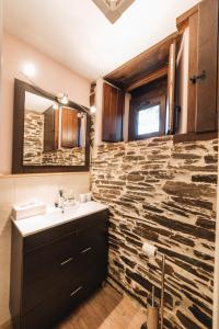 a bathroom with a sink and a stone wall at CASA TRISQUEL 