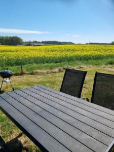 a wooden table and chairs in front of a field at dala källebacka in Stenstorp