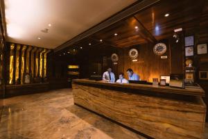 a group of people standing at a bar at Hotel Millennium Inn, Prayagraj in Allahābād