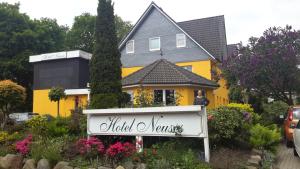 un hombre parado frente a una casa amarilla en Hotel Neuses, en Cuxhaven