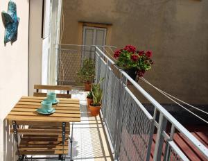 a balcony with a wooden table and potted plants at Casa Del Monte in Naples