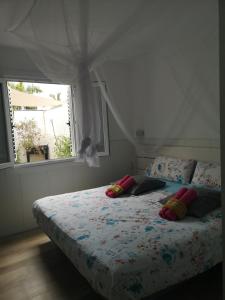 a bedroom with a bed with pillows and a window at Yumbo room in Maspalomas