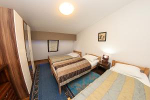 una camera con due letti e una luce sul soffitto di Apartments Cyrano 1&2 a Sarajevo
