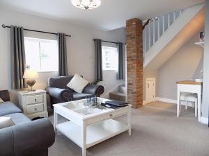 a living room with a couch and a table at Double Award Winning, Stunning 1700's Grd 2 listed cottage near Stonehenge - Elegantly Refurbished Throughout in Amesbury