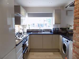 a kitchen with a sink and a dishwasher at Double Award Winning 1700's Grd 2 listed cottage near Stonehenge in Amesbury +45 photos