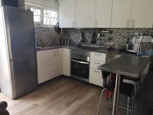 a kitchen with white cabinets and a black refrigerator at Yumbo room in Maspalomas