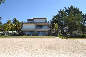 a house on the beach with trees and sand at Summer Breeze - Beachfront - 3 Bedrooms Suite in Pointe d'Esny