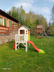 a playground with a slide and a play house at Całoroczny dom GRODZIANKA in Banie Mazurskie