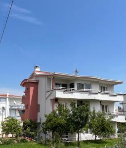 a red and white building with trees in front of it at Apartments Ela in Ulcinj