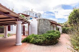 a large white house with a brick driveway at Villa with private access to the sea in Forio D'Ischia in Ischia
