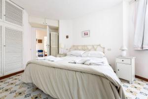 1 dormitorio blanco con 1 cama grande con sábanas blancas en Villa with private access to the sea in Forio D'Ischia en Ischia