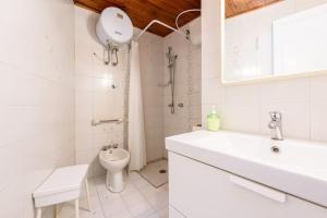 a white bathroom with a sink and a toilet at Villa with private access to the sea in Forio D'Ischia in Ischia