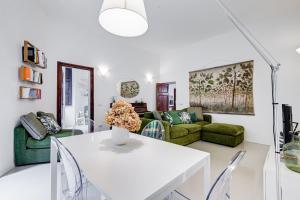 sala de estar con mesa blanca y muebles verdes en Colosseo Exclusive House by Premium Suites Collection, en Roma