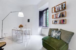 una sala de estar con una silla verde y una mesa en Colosseo Exclusive House by Premium Suites Collection, en Roma