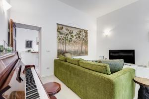 sala de estar con sofá verde y piano en Colosseo Exclusive House by Premium Suites Collection, en Roma