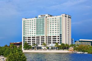 a hotel building with a beach in front of the water at The Westin Tampa Bay in Tampa